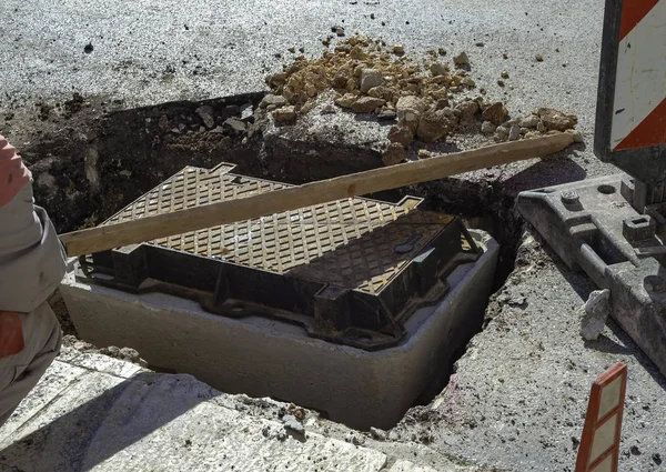 통신용 광섬유 유통망 작업자가 커버를 맨홀에 배치합니다 — 스톡 사진