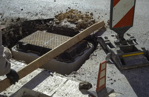통신용 광섬유 유통망 작업자가 커버를 맨홀에 배치합니다 — 스톡 사진