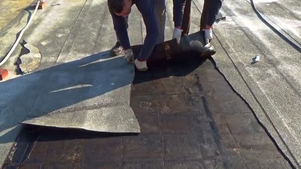 Workers remove the damaged bituminous layer from the flat roof of a building — Stock Footage Workers Remove Damaged Bituminous Layer Flat Roof Building Video Clip