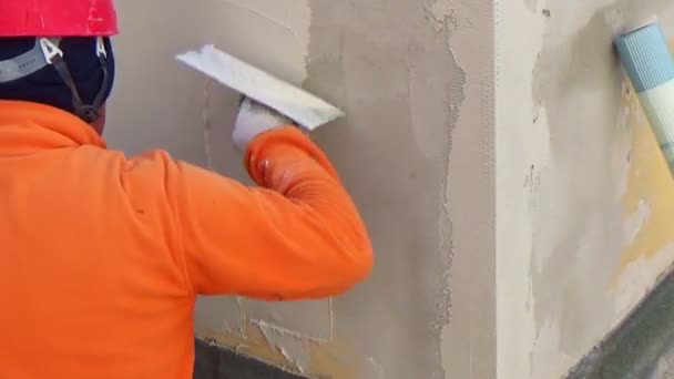 建筑工人手拿着美国大肠贴在墙上 — 图库视频影像