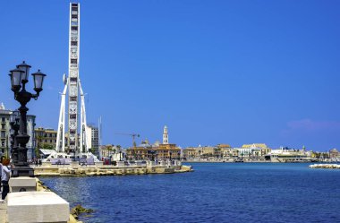 Bari, İtalya - 13 Mart 2018: karakteristik lamba direği ön planda ve arka planda deniz kıyısına monte edilmiş dönme dolap