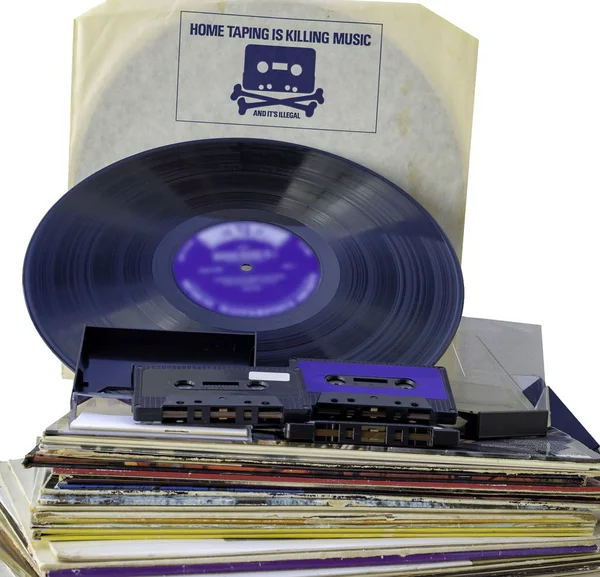 反盗版广告在旧乙烯基唱片的封面 一叠旧乙烯基 Rpm 和一些盒式磁带 — 图库照片