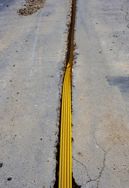 Telekomünikasyon dağıtım ağı için fiber optik kablolar çalıştırmak için gömülü plastik kanallar için kısıtlı bir bölüm kazmak.