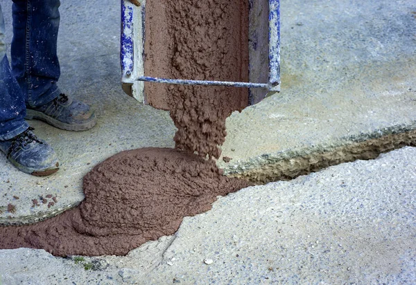 Filling with colored concrete of excavation with a narrow section for the implementation of a fiber optic distribution network for telecommunications. — Stock Image Filling Colored Concrete Excavation Narrow Section Implementation Fiber Optic Distribution Royalty Free Stock Photos