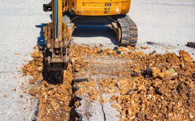 Yeni ağ altyapı fiber optiklerinin çalışmasında küçük genişlikte kazı yapmak için çok dar bir kova ile donatılmış mini kazıcı