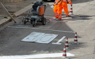 Yol inşaatındaki makine ve işçiler yol ve trafik işaretleri boyası için kullanılıyor