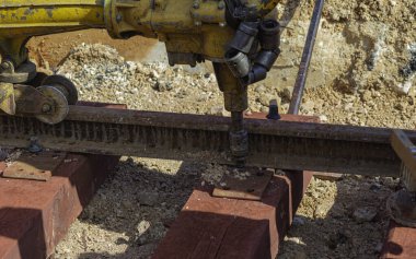 Rayları sürgüleyen demiryolu işçileri. Hafif portatif sondaj makinesi olan detaycı.