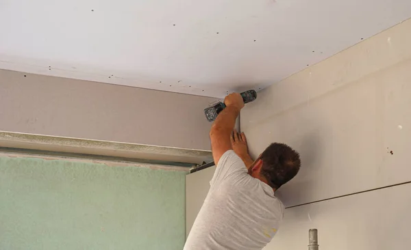 Nşaat Işçisi Asılmış Tavanı Bir Alçıpanla Monte Ediyor Alçıpanı Tornavidayla — Stok fotoğraf