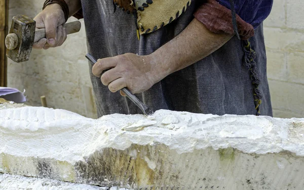 Stonemason With Ancient Costume During The Processing Of The Stone With Chisel