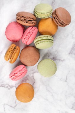 Mermer arka plan üzerinde renkli kurabiye. Tatlı macarons. Metniniz için kopya alanı ile üstten görünüm.