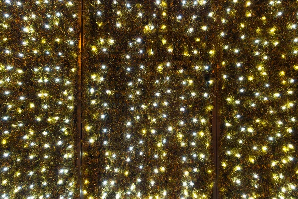 Twinkling christmas lights background. Wall illuminated by Christmas lights