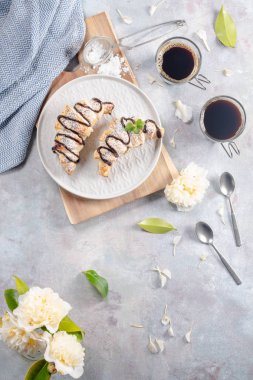 Leziz continental kahvaltı taze lapa lapa Fransız kruvasan ve kahve, kruvasan kapatın. Hafif bir arka plan üzerinde beyaz Kamelya çiçeklerle. Provence rustik tarzı. Üstten görünüm. Düz yatıyordu