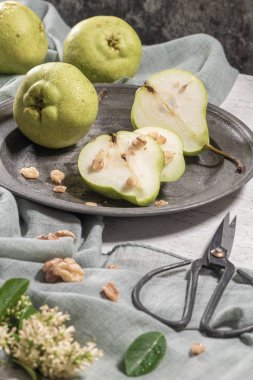 Fındık ile lezzetli armut. Çiçeklerle süslenmiş bir masa ve plakaya kesilmiş bir tabak armut.