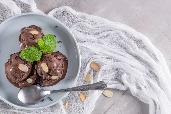 Teller Schokoladeneis mit Mandelscheiben und Minzblättern — Stockfoto