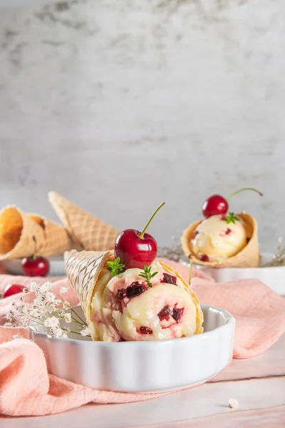 Coni di cialde tradizionali con gelato e frutti di ciliegia sulla superficie in pietra di marmo — Foto Stock