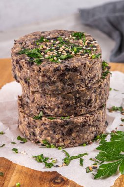 Tahta tezgahta siyah fasulyeli çiğ vejetaryen burger..