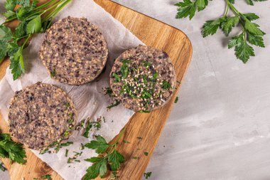 Tahta tezgahta siyah fasulyeli çiğ vejetaryen burger..