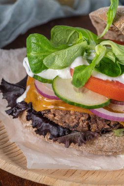Mutfak tezgahında taze sebzeli ve yoğurt soslu sağlıklı vejetaryen burger..