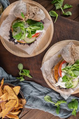 Rustik mutfak tezgahı üst taze sebze ve yoğurt soslu sağlıklı vegan burger. Üstte görüntü