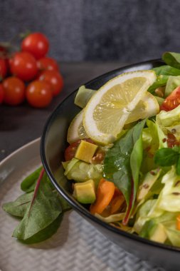 Salata. Bahar sebze salatası. Domatesli, elmalı, fındıklı, tohumlu ve limonlu taze sebze salatası. Salata kasesine zeytin yağı dökülüyor.