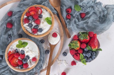 Sağlıklı kahvaltı için yoğurt ve böğürtlen. Bir kase Yunan yoğurdu, ahududu, yabanmersini ve çilek. Üst görünüm