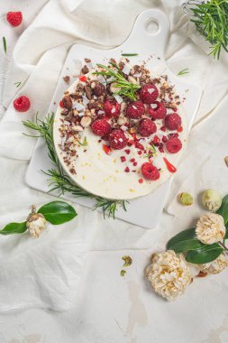 Mutfakta ahududu, çikolata, fındık ve biberiye yapraklı cheesecake.