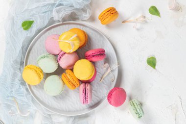 Renkli Fransız kurabiyeleri. Beyaz masa arkaplanında yasemin çiçekli kurabiyeler. Seçici odak