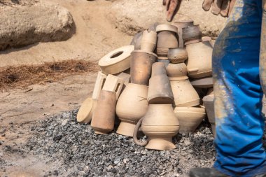 AMARANTE, PORTUGAL - CRCA APRIL 2022: 2022 Nisan 2022 'de Portekiz' in Amarante şehrinde Gondar 'ın kara kilinin ateşleme işlemi sırasında şenlik ateşinin közlerinin üzerine kil parçaları istiflemek.