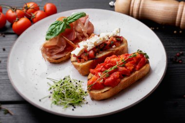 Jambon ve beyaz tabakta domates ile üç sandviç dikey fotoğraf