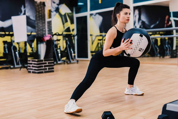 Atletische jonge vrouw doen oefening met med bal. Kracht en motivatie. — Stockfoto