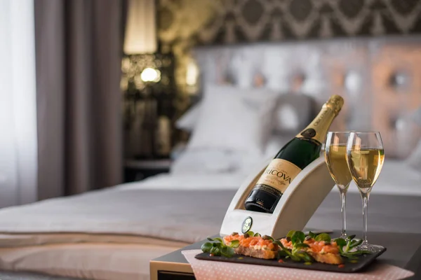 Luxury hotel room with a table with snacks and champagne