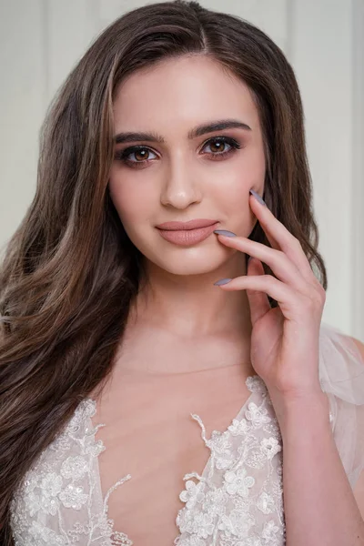 Gorgeous brunette bride in luxury white lingerie. Makeup Details. Thick and long eyelashes. Nude Lipstick on Plump Lips. Closeup portrait girl. perfect makeup for the bride - Image