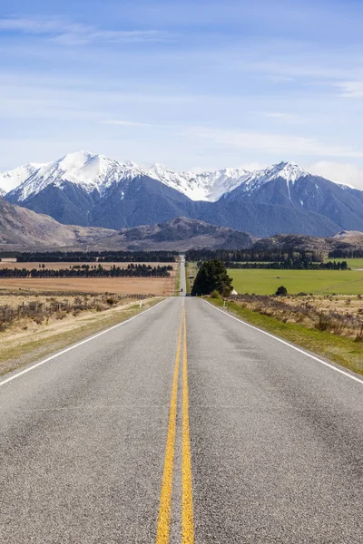 Largo camino recto y montañas en Arthurs Pass, Nueva Zelanda — Foto de Stock