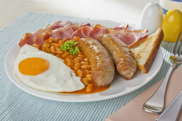 Engels ontbijt van worst, spek, ei en gebakken bonen — Stockfoto