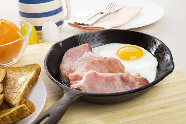 Bacon och ägg i en gjuten järn stekpanna — Stockfoto