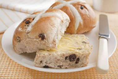 Tereyağlı sıcak Cross Buns sarı kumaş üzerine