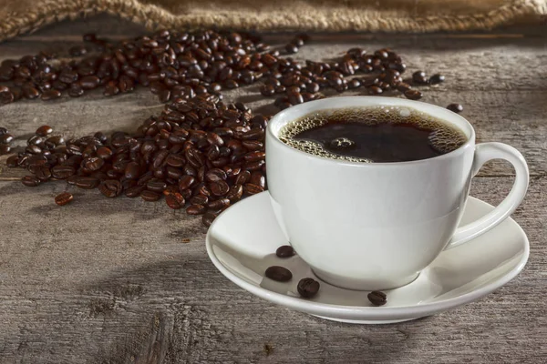 Coffee Cup and Coffee Beans 0n Rustic Background