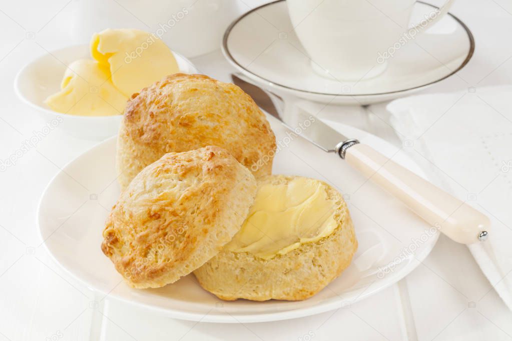 Fresh homemade cheese scones with butter on white