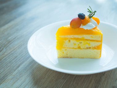 Mix Meyve beyaz tabakta tepesi ile turuncu kek