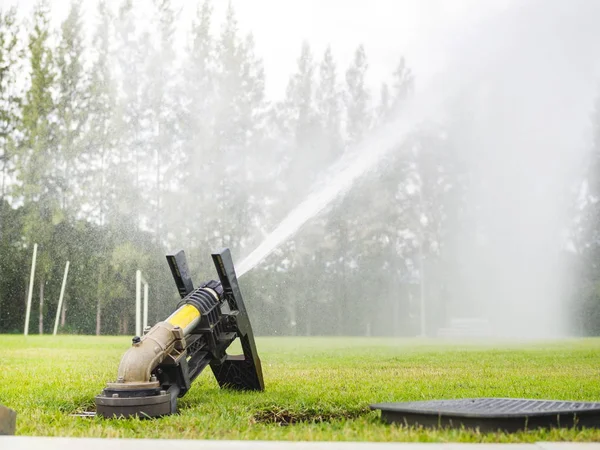 stock image Sprinkler watering football field, Sprinkler watering green grass in football field