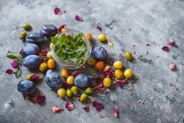 Nane ve dağınık mavi ve Sarı Erik gri bir arka plan üzerinde bir kavanoz