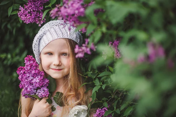 Ritratto all'aperto di una bambina carina contro la bella lilla in una bella giornata primaverile — Foto Stock