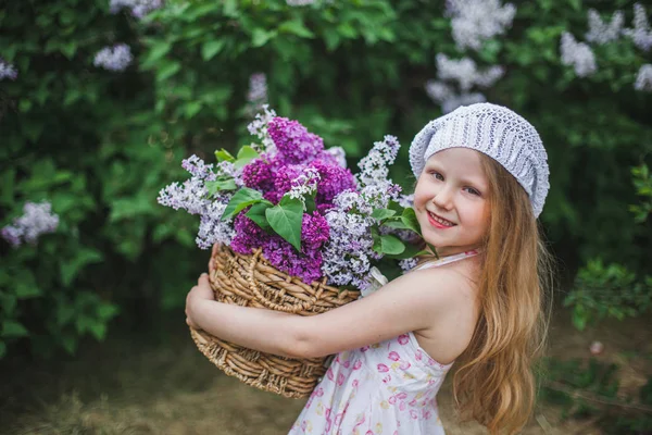 Портрет симпатичной маленькой девочки на фоне красивого лилака в прекрасный весенний день — стоковое фото