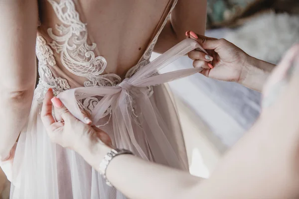 A noiva amarrou o cinto no vestido de noiva. Curva-te no close-up de trás. Preparativos matinais antes do casamento — Fotografia de Stock