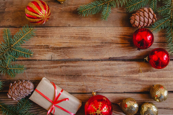 Рождественская квартира макет ели ветвей, ремесленные подарки, конусы, красные и золотые безделушки на деревянном фоне. Copyspace 