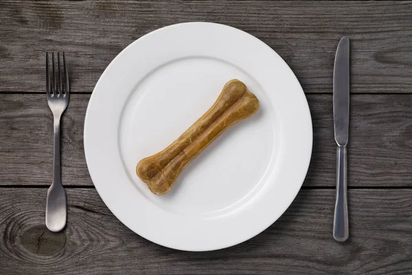 Yiyecek bir şey yok: ahşap bir masa, bir üstten görünüm beyaz bir tabağa bir kemik. Aç zaman