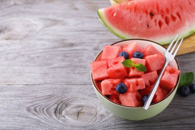 Ahşap bir masa üzerinde yaban mersini ile karpuz dilimli adet plaka