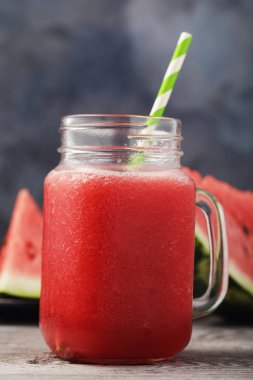Ahşap bir masa üzerinde şeffaf bir kavanoza bir karpuz üzerinden pişmiş smoothies yakın çekim