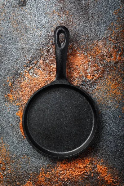 Empty black cast iron pan on an old protvine, top view