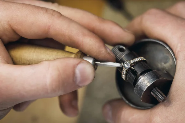 Jeweler adjusts precious stones in a gold ring, close-up — Stock Photo, Image